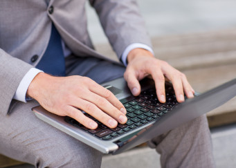 close up of business man with laptop in city